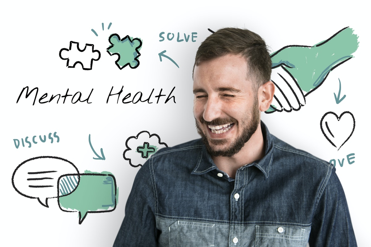 man smiling in front of white board about mental health