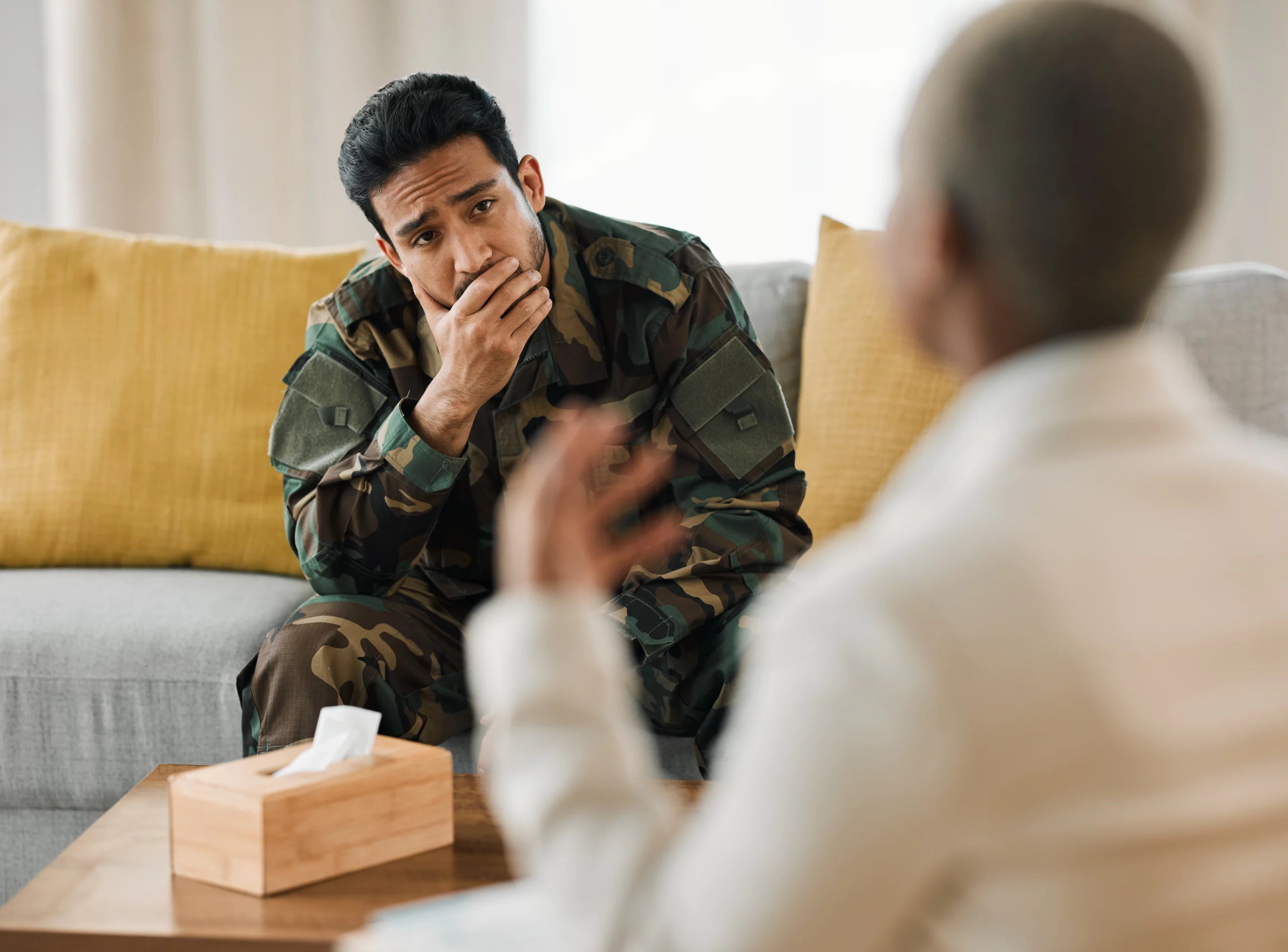 military man in uniform sitting with therapist during individual therapy session