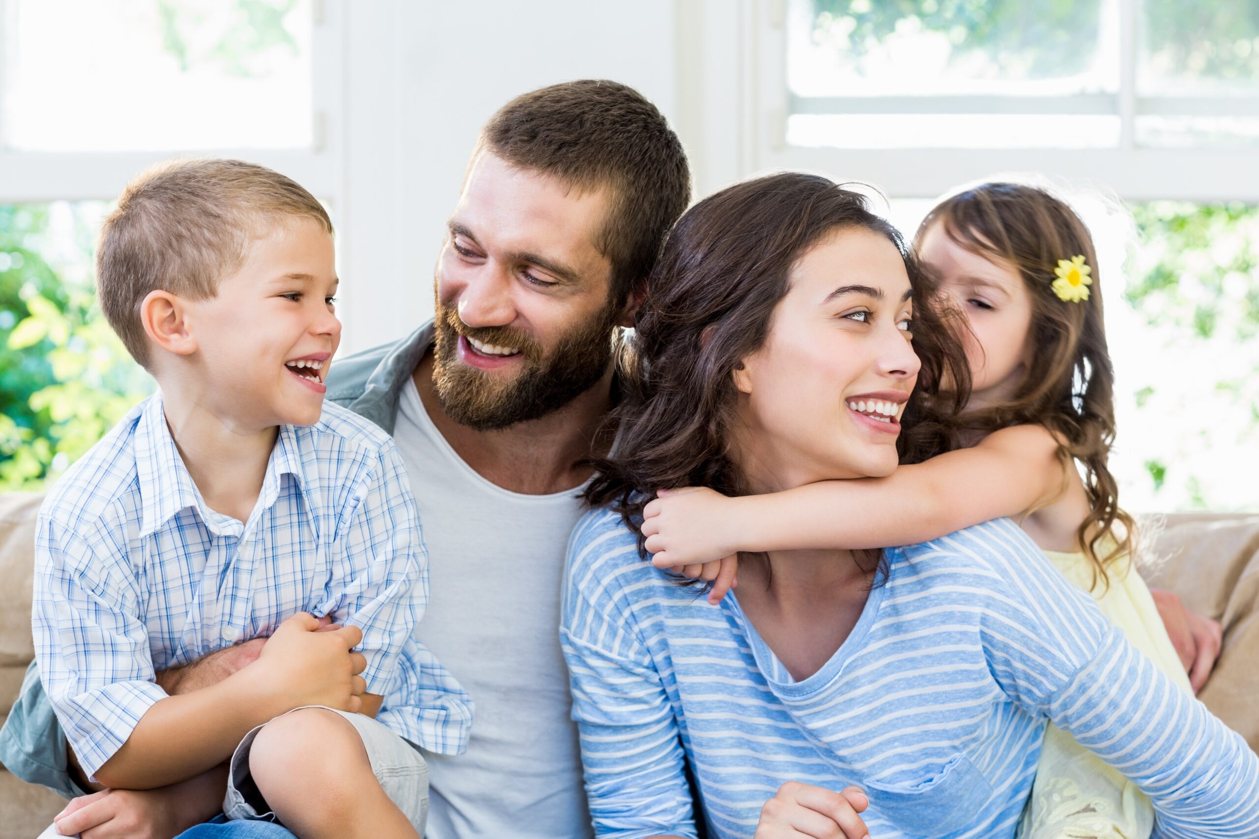 Parents and kids sitting on sofa and having fun