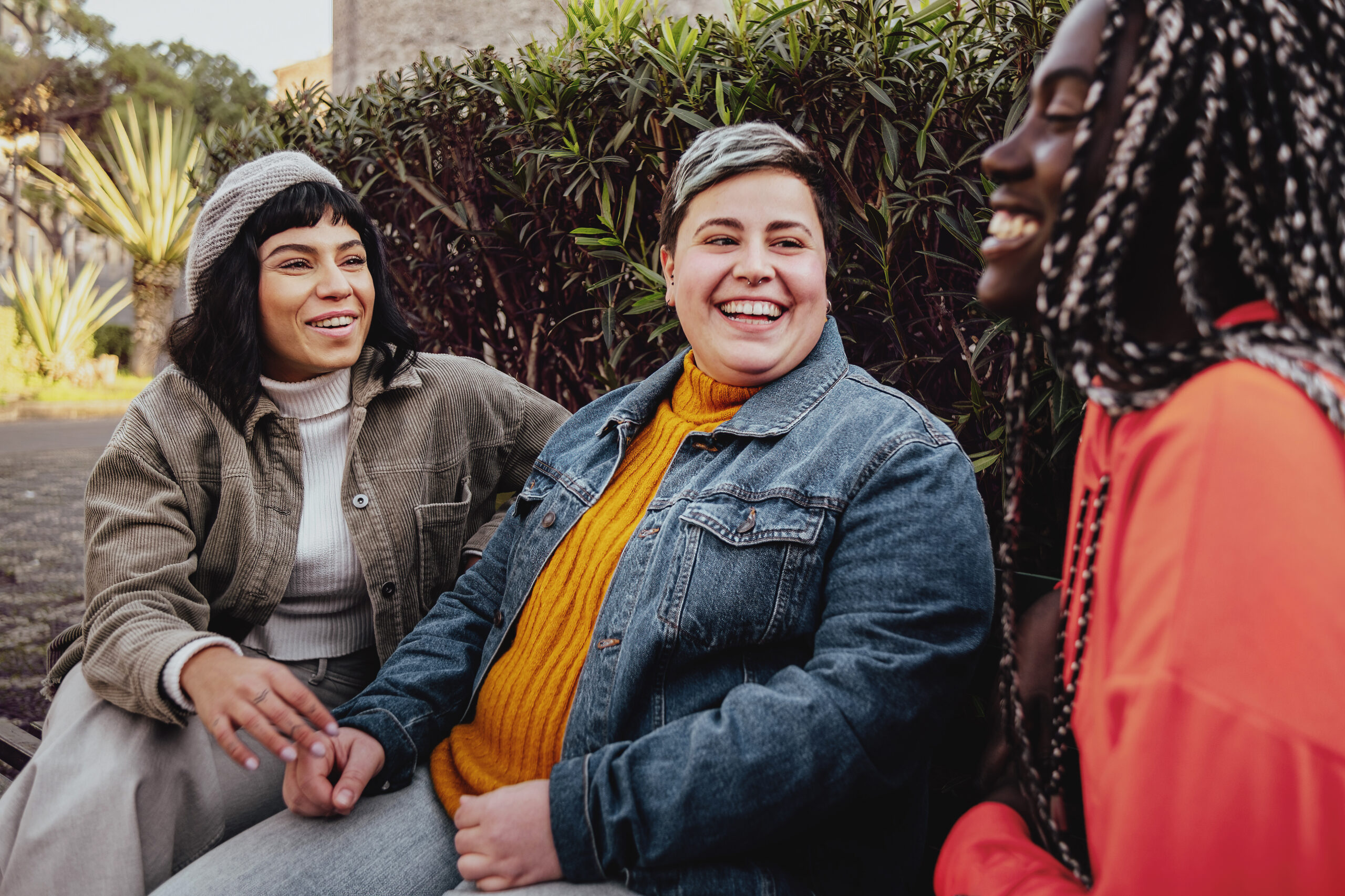 Group of diverse cheerful women friends sitting in outdoors