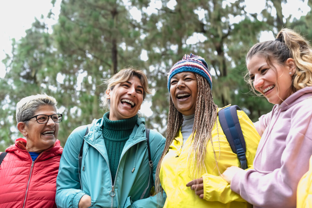 Group of women with different ages and ethnicities having fun walking in the woods