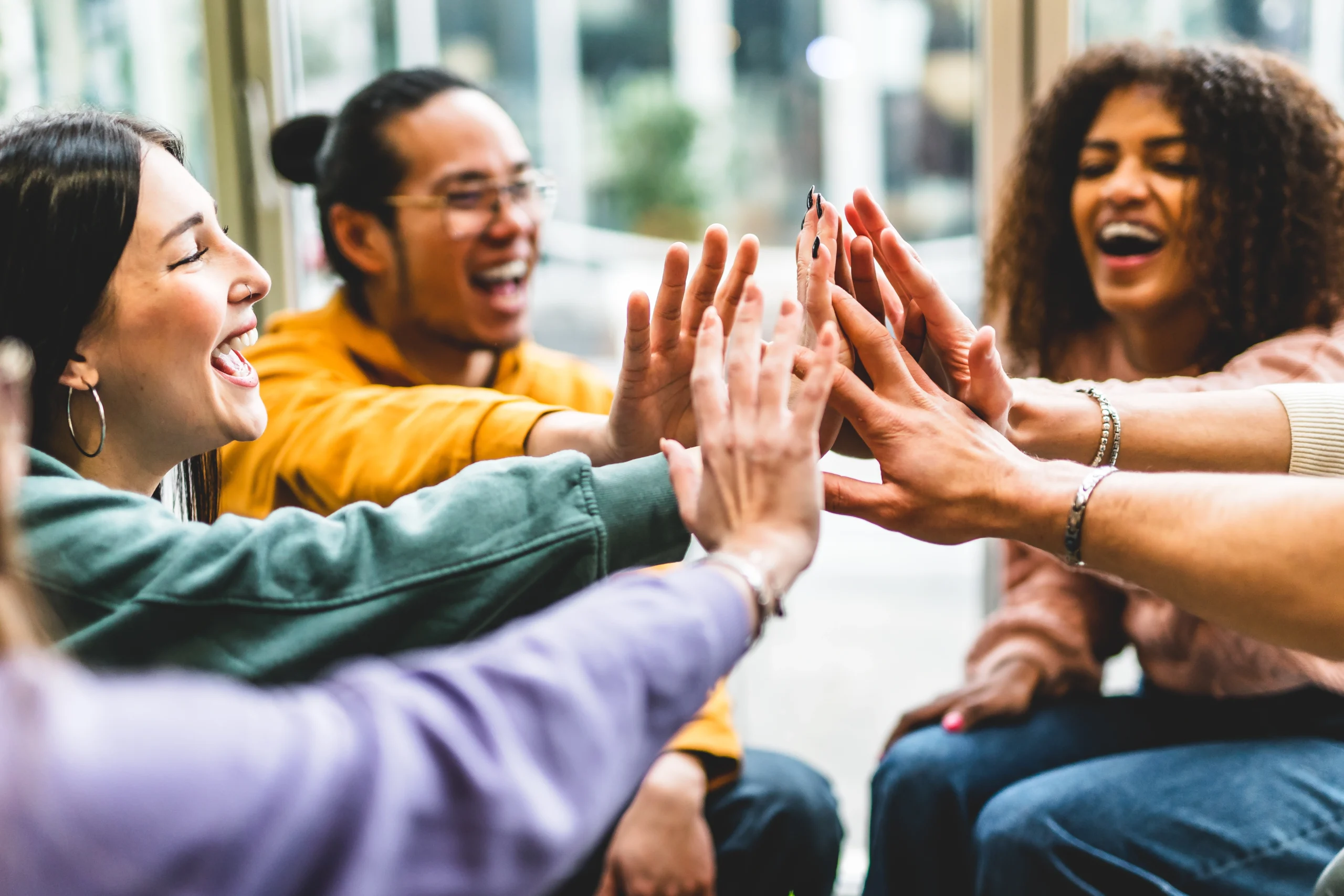 a group of lively people in a behavioral health group high fiving